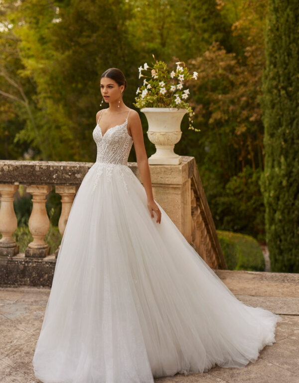 Το νυφικό φόρεμα Venuz αποπνέει ρομαντισμό και γοητεία. Η σιλουέτα του φορέματος με Sweetheart ντεκολτέ είναι στολισμένο με λαμπερό κέντημα και τιράντες επίσης κεντημένες με χάντρες. Οι νύφες λατρεύουν την αποκαλυπτικά ανοικτή πλάτη και διαφάνεια σε όλο το μπούστο , Η φούστα του νυφικού έχει πολλαπλές στρώσεις από τούλι αστραφτερά εκθαμβωτικό με μια ουρά πραγματικά πριγκιπική.